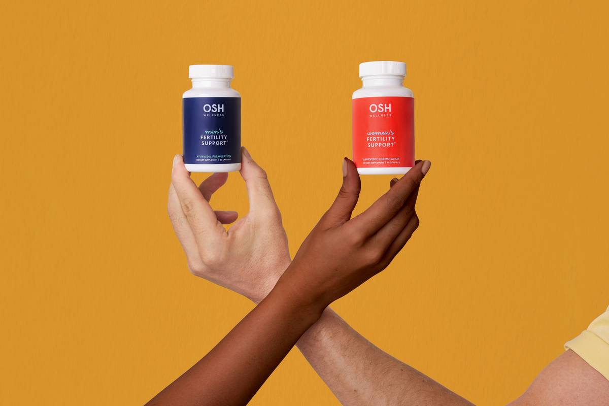 A person holding a bottle of probiotic supplements next to a glass of water, illustrating how to take probiotics properly